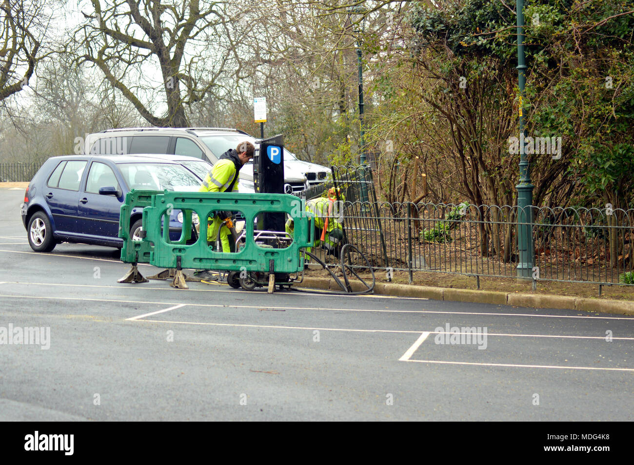 Workmen putting in new parking meter in a car park in Hyde Park, London
