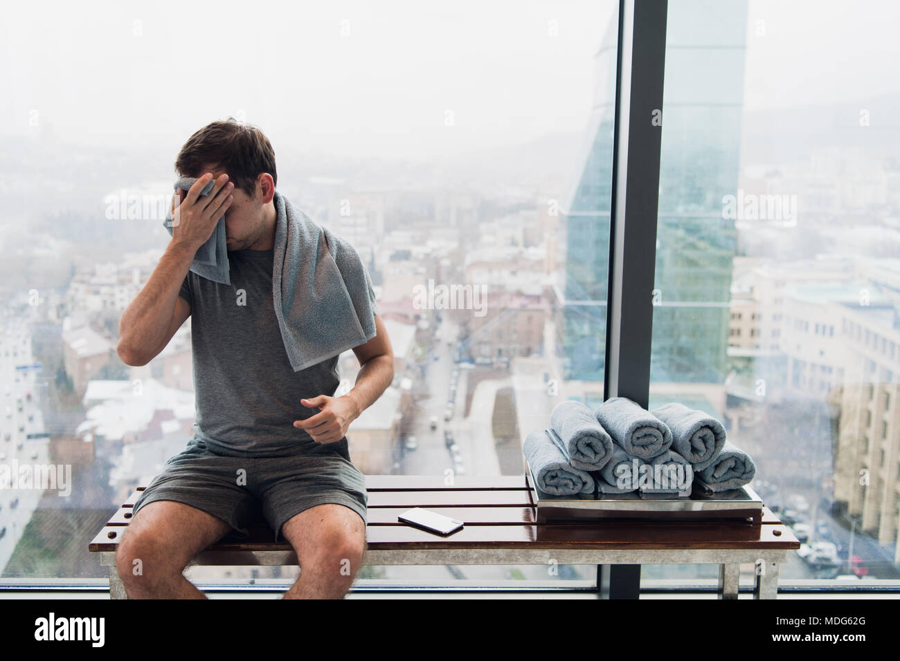 Young Man In Gym After Workout Sitting On A Bench In Front Of