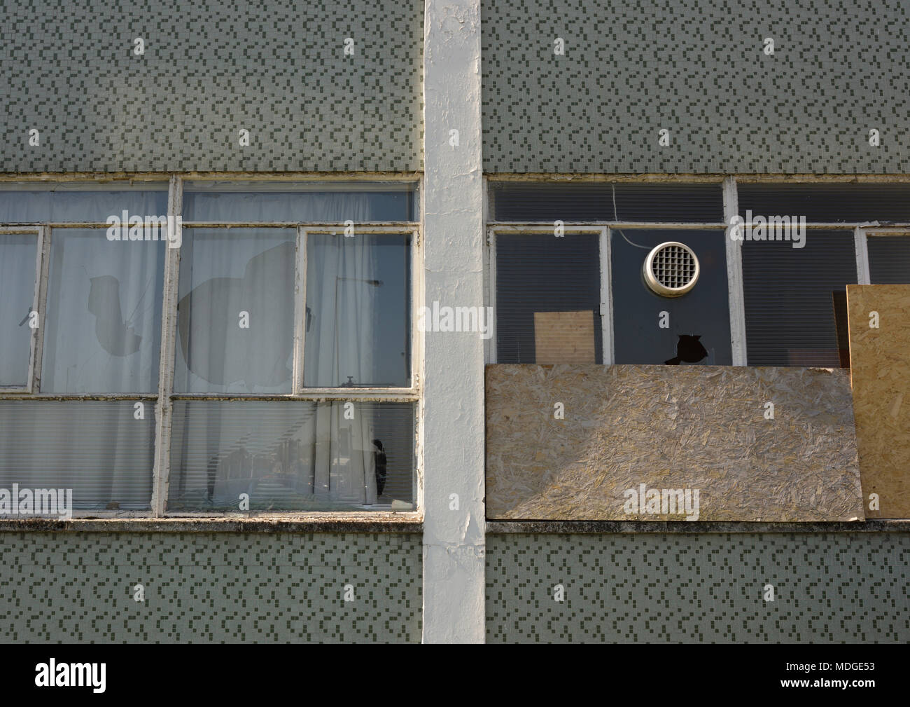 Broken windows and boarded up windows in disused fire station in bury lancashire uk Stock Photo