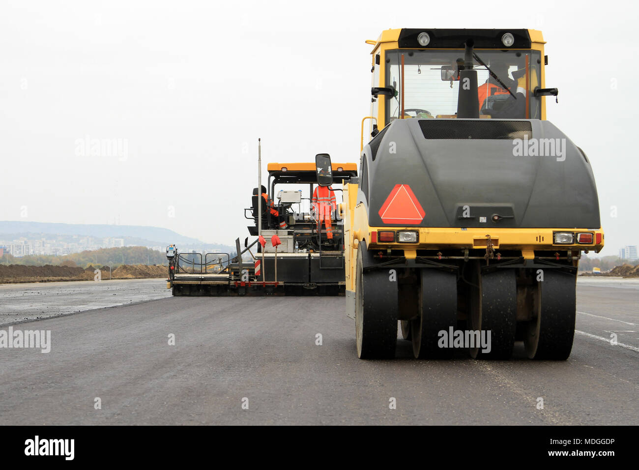 Road roller machine and pavement spreader machine works Stock Photo Alamy