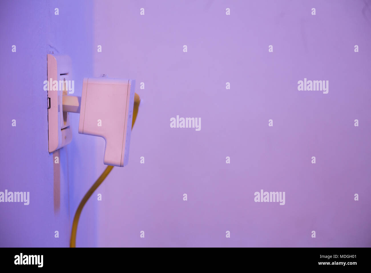 WiFi extender in electrical socket on the wall with cable