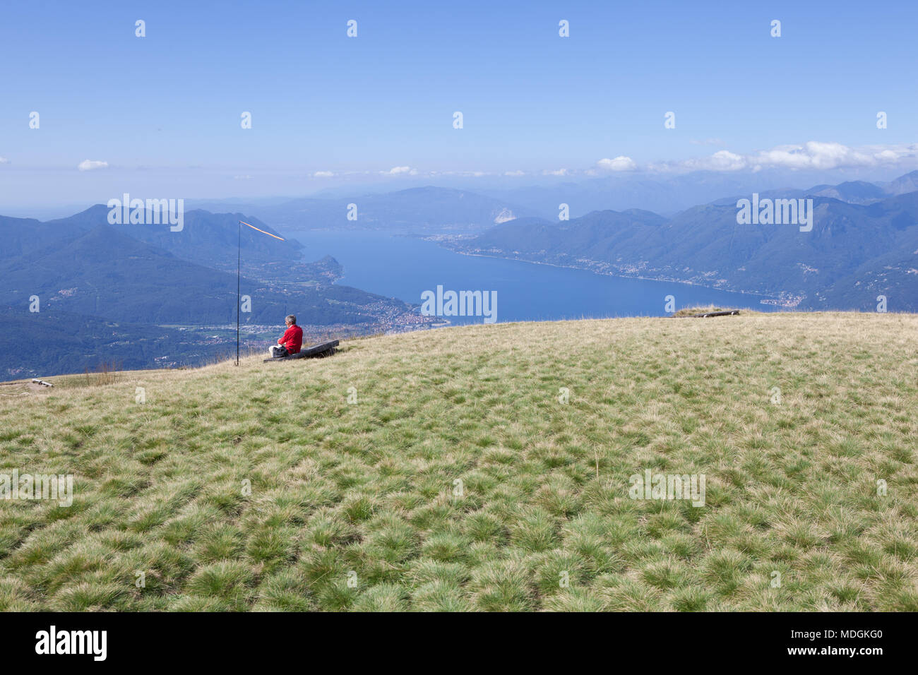 A tourist contemplating the beautiful view of Lago Maggiore (Lake Maggiore) from the top of Monte Lema (Mount Lema). Miglieglia, Switzerland Stock Photo