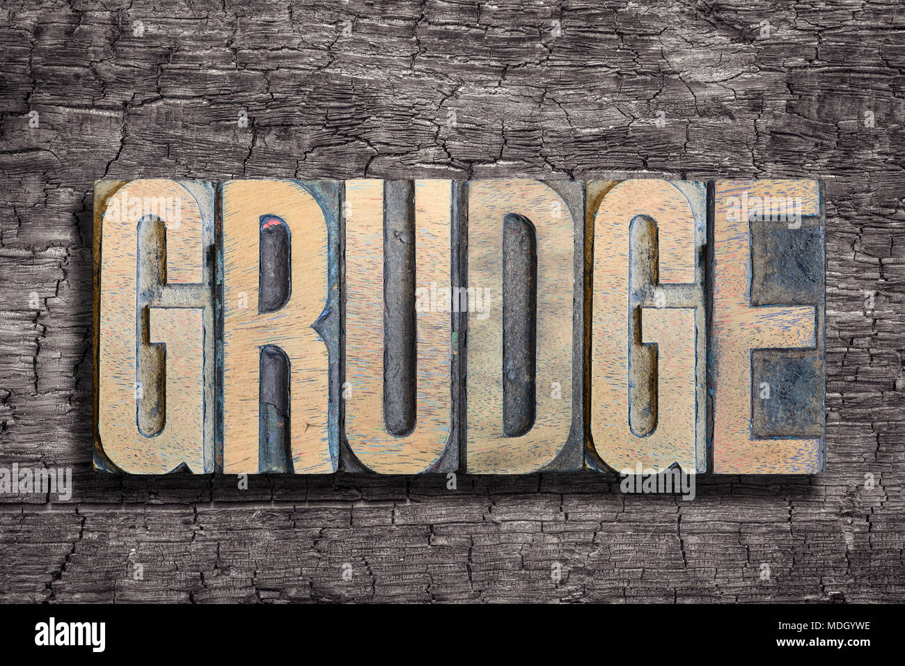 grudge word made from vintage letterpress type on burned wood background Stock Photo