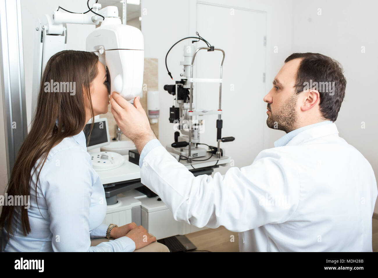 ophthalmologist examining patient at clinic Stock Photo