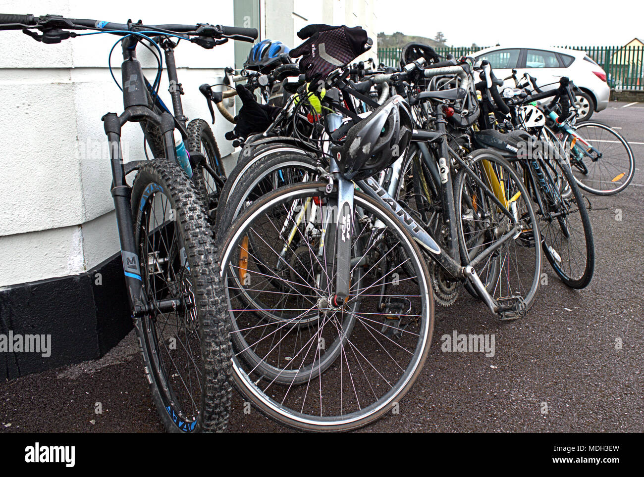 bicycles stacked against a cafe wall in skibbereen, ireland prior to being used for a charity bike ride by female students. Stock Photo
