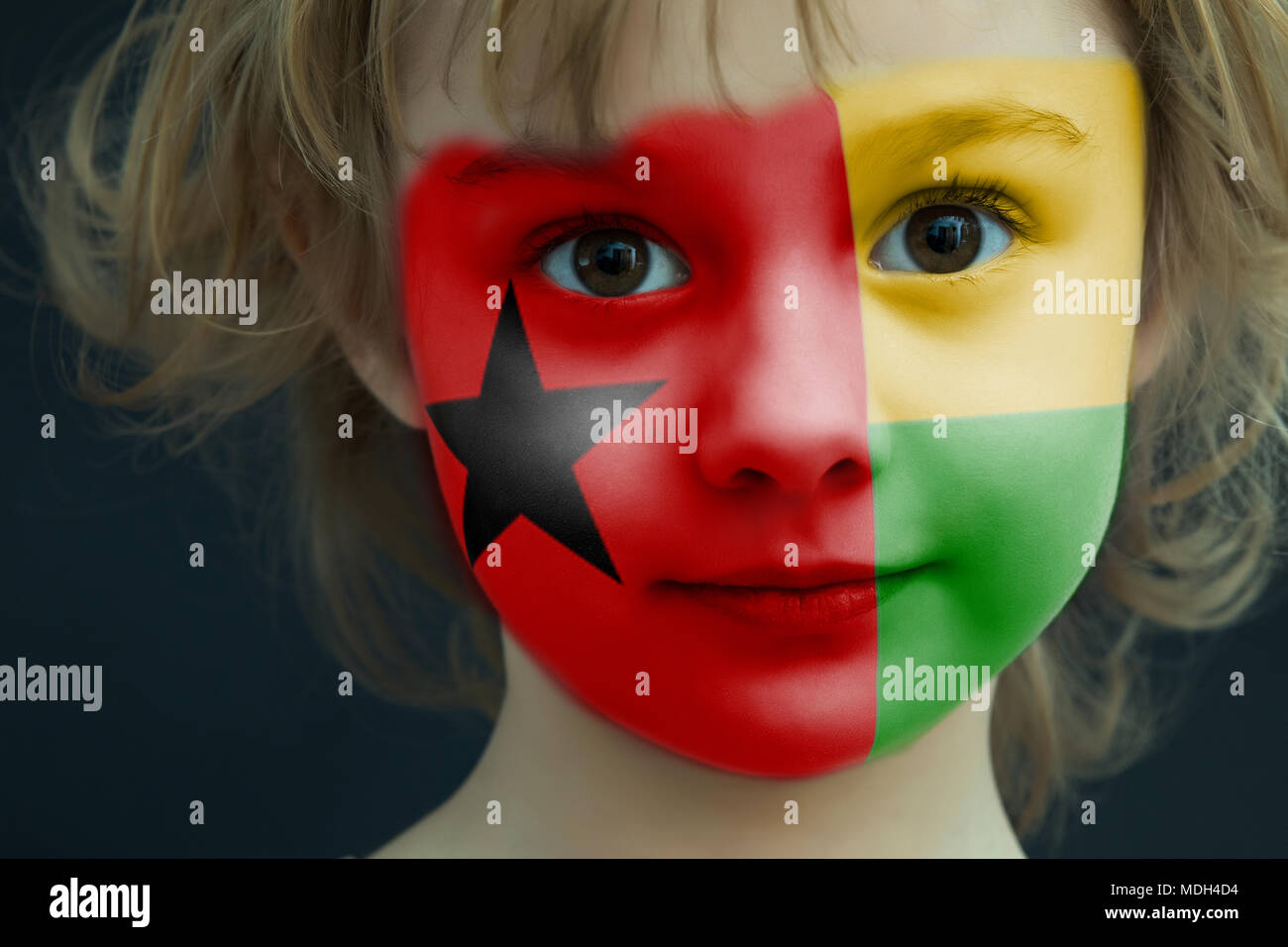 Child with a painted flag of Guinea Bissau Stock Photo