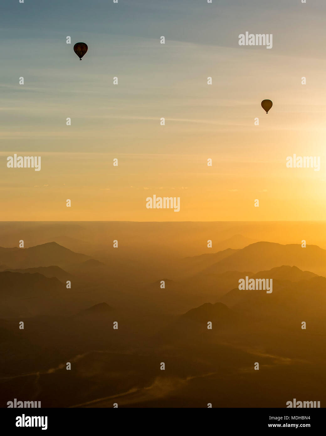 Silhouette of hot air balloons in the golden sky over the sand dunes at sunrise in the Namib Desert; Sossusvlei, Hardap Region, Namibia Stock Photo