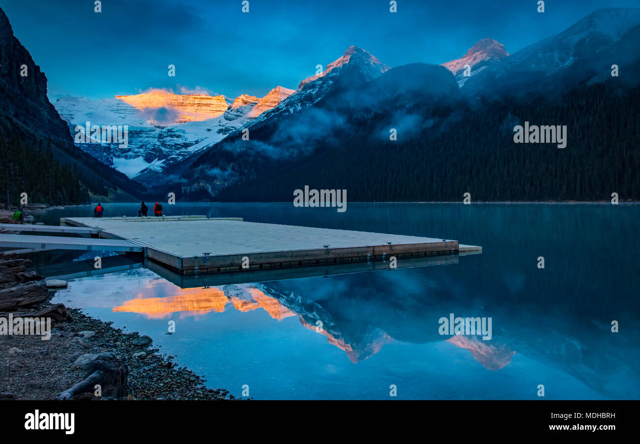 Peaks of the Rocky Mountains illuminated by sunlight and reflected in ...