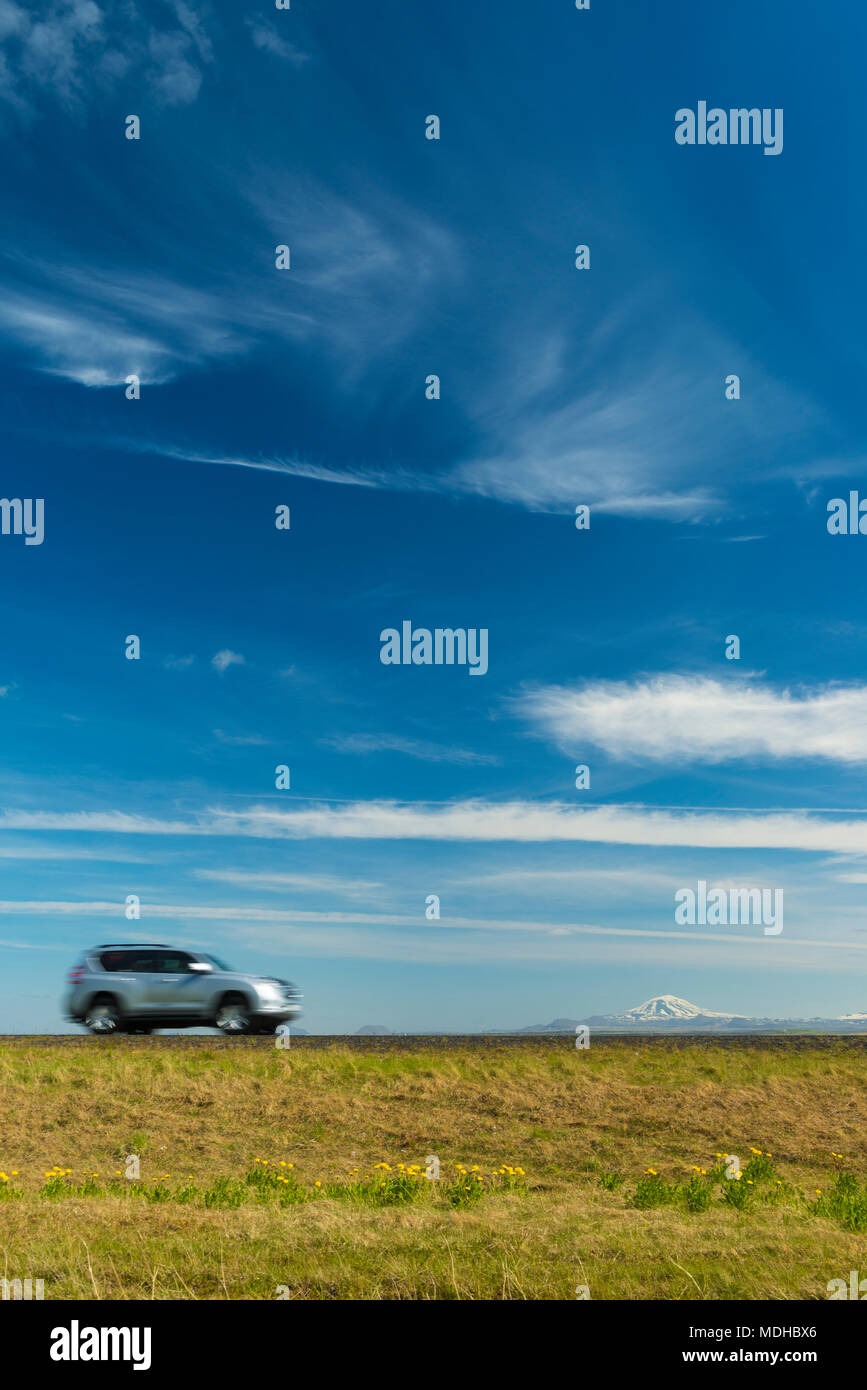 Vehicle driving on open road near Hella with Hekla volcano in the distance; Iceland Stock Photo