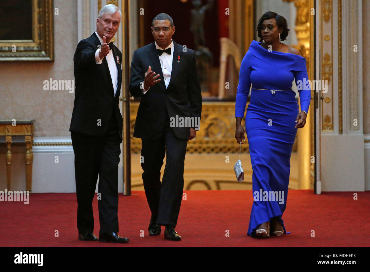 Jamaica's Prime Minister Andrew Holness (centre) and his wife Juliet arrive in the East Gallery at Buckingham Palace in London as Queen Elizabeth II hosts a dinner during the Commonwealth Heads of Government Meeting. Stock Photo