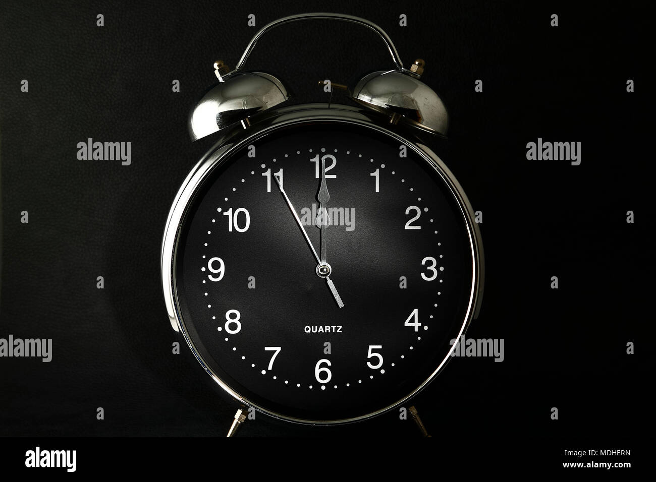 Old retro alarm clock with the hands set to 12:00 am or 12 pm Stock Photo