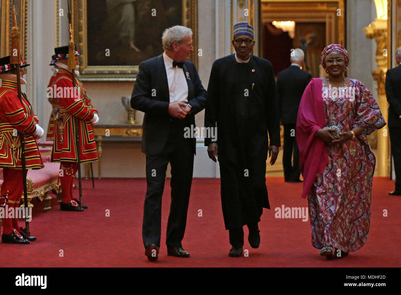 Nigeria's President Muhammadu Buhari (centre) and his wife Aisha arrive in the East Gallery at Buckingham Palace in London as Queen Elizabeth II hosts a dinner during the Commonwealth Heads of Government Meeting. Stock Photo