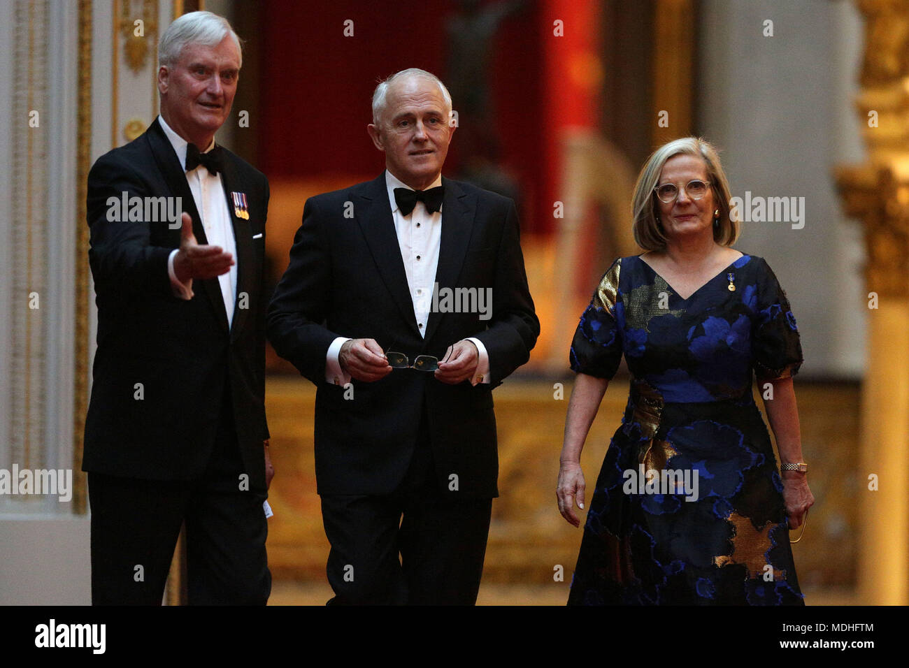 Australia's Prime Minister Malcolm Turnbull (centre) and his wife Lucy arrive in the East Gallery at Buckingham Palace in London as Queen Elizabeth II hosts a dinner during the Commonwealth Heads of Government Meeting. Stock Photo