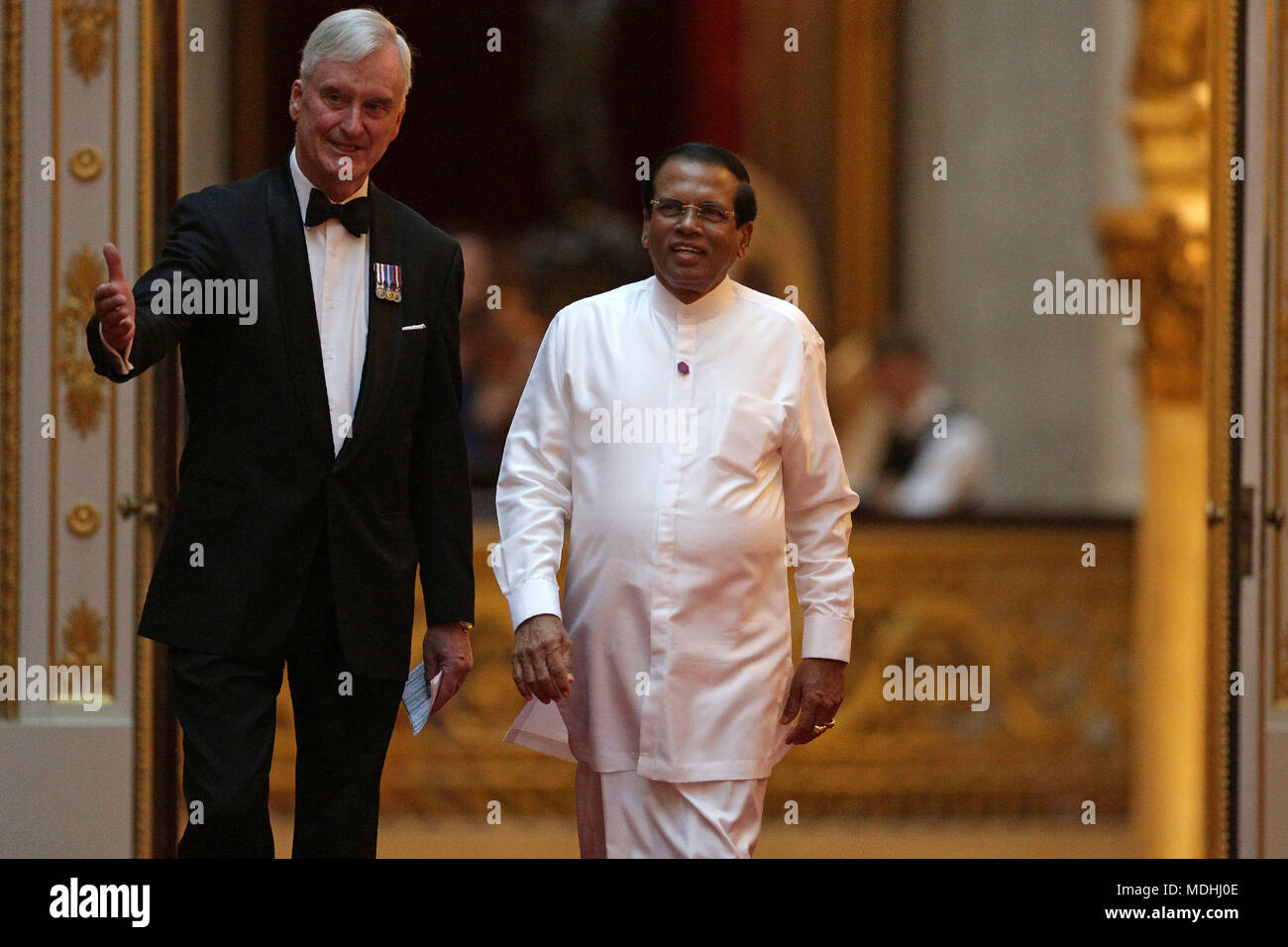 Sri Lanka's President Maithripala Sirisena (right) arrives in the East Gallery at Buckingham Palace in London as Queen Elizabeth II hosts a dinner during the Commonwealth Heads of Government Meeting. Stock Photo
