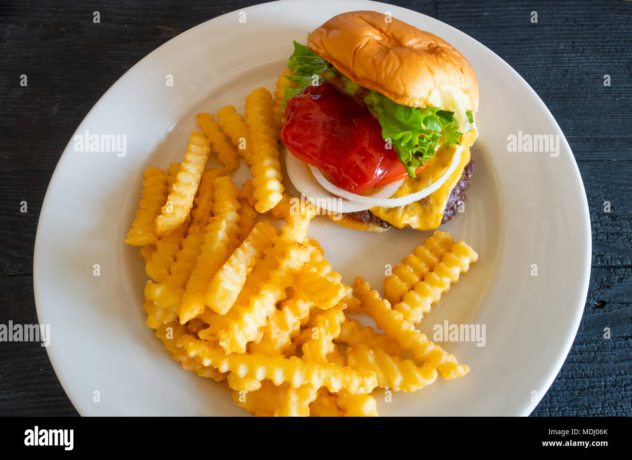 Cheeseburger and crinkle cut fries Stock Photo