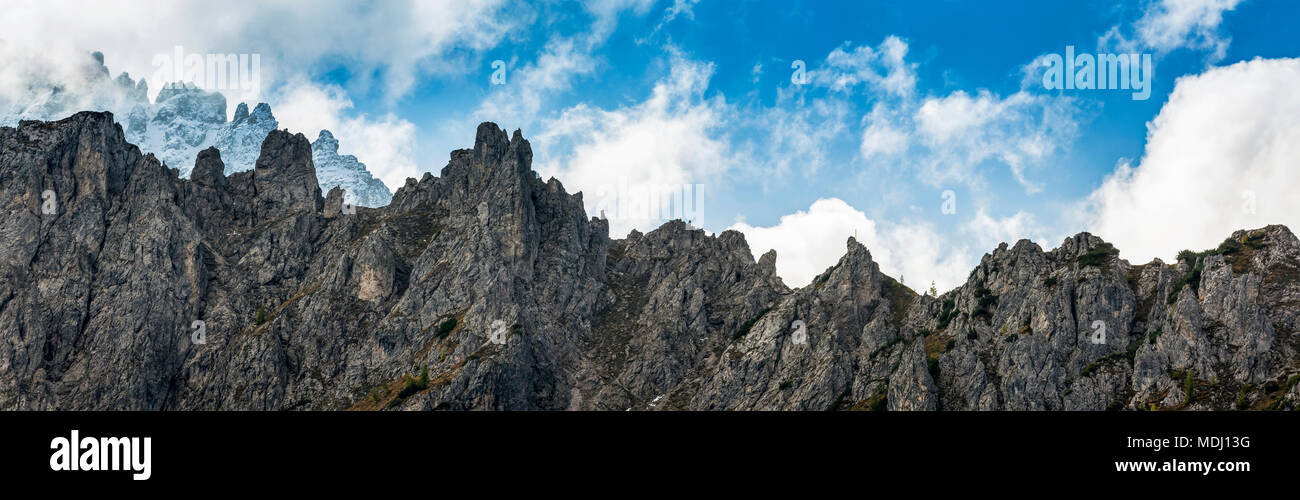 Panorama of rugged mountain peaks with blue sky and cloud; Sesto, Bolzano, Italy Stock Photo