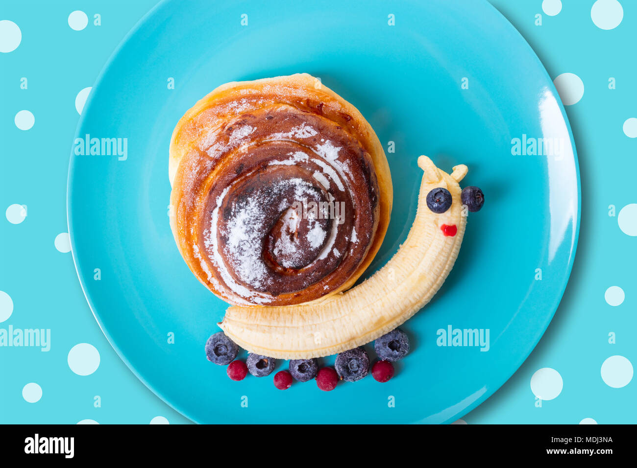 art food for children, snail from banana and bun Stock Photo
