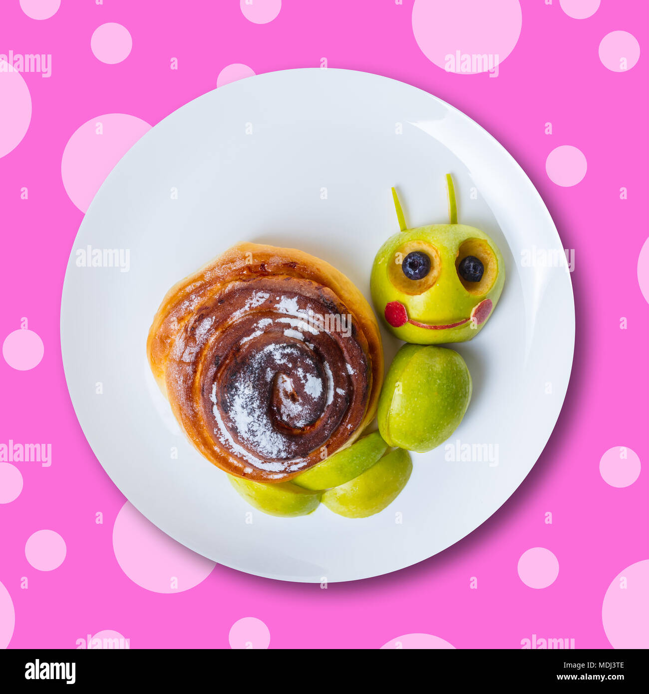 art food for children, snail from green apple and bun Stock Photo