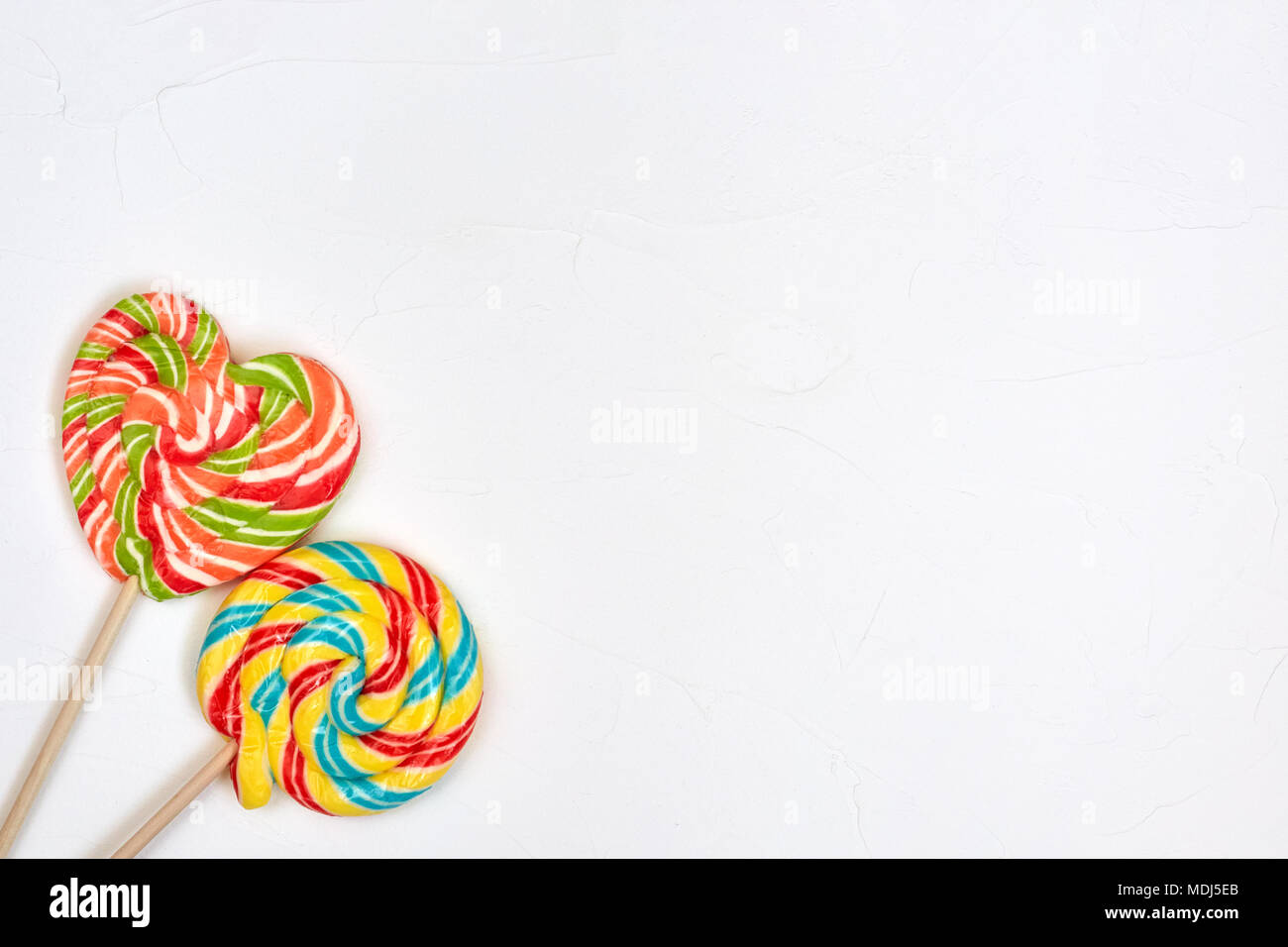 Swirl rainbow lollipop candy on white background, copyspace Stock Photo