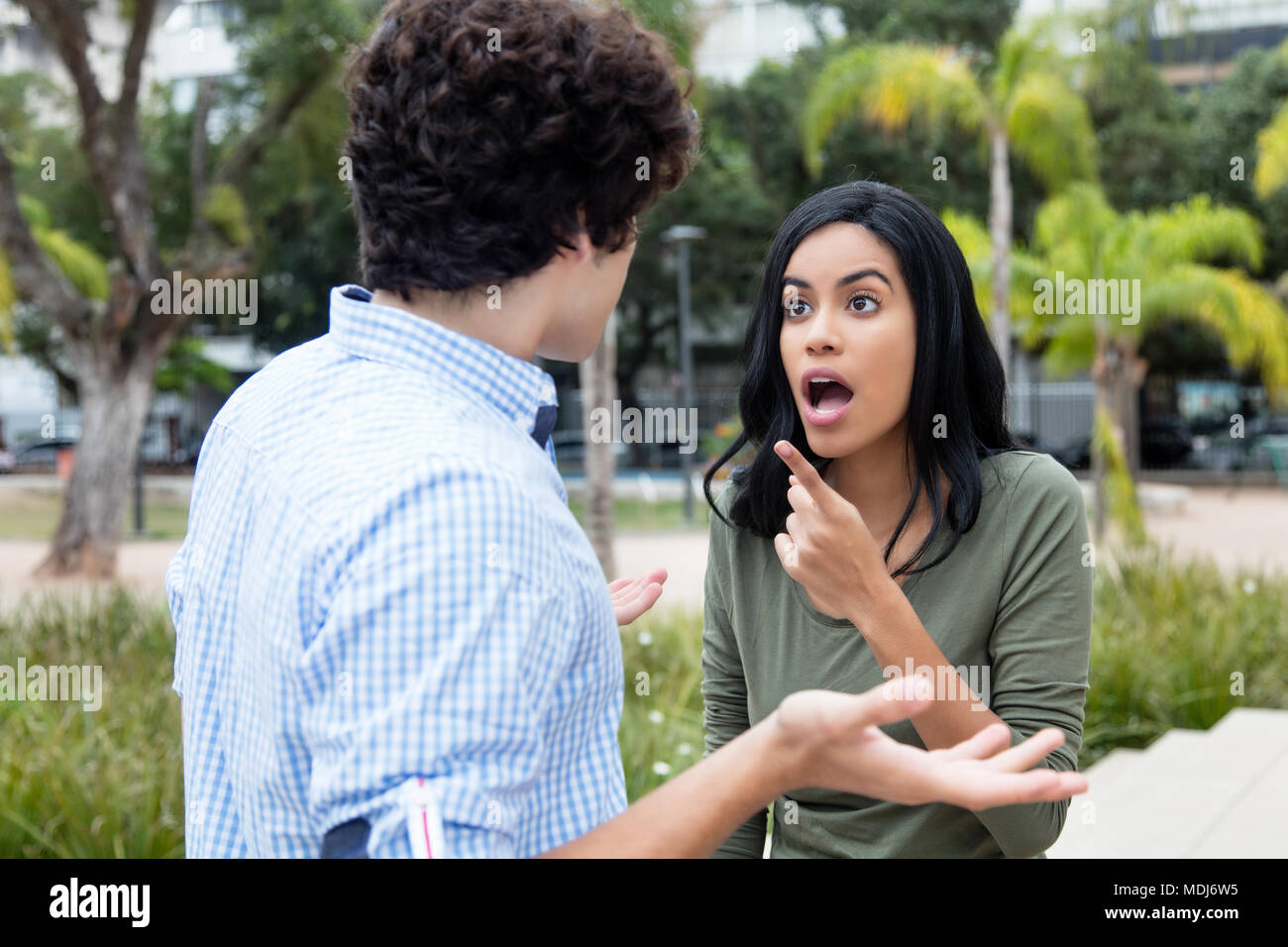 Shocked young woman with boyfriend outdoors in the city Stock Photo