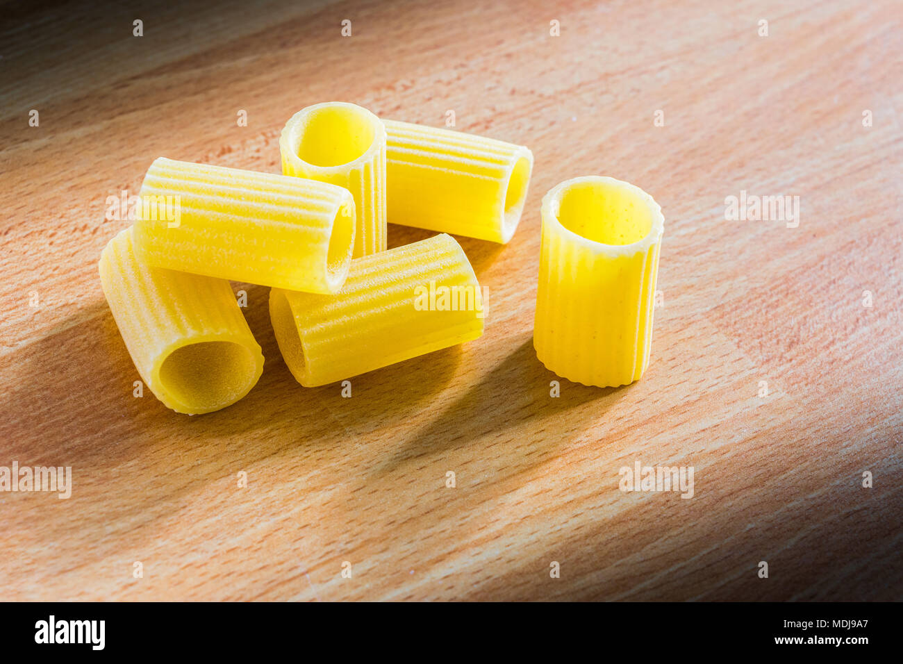 Italian pasta (mezze maniche) on a wooden table Stock Photo
