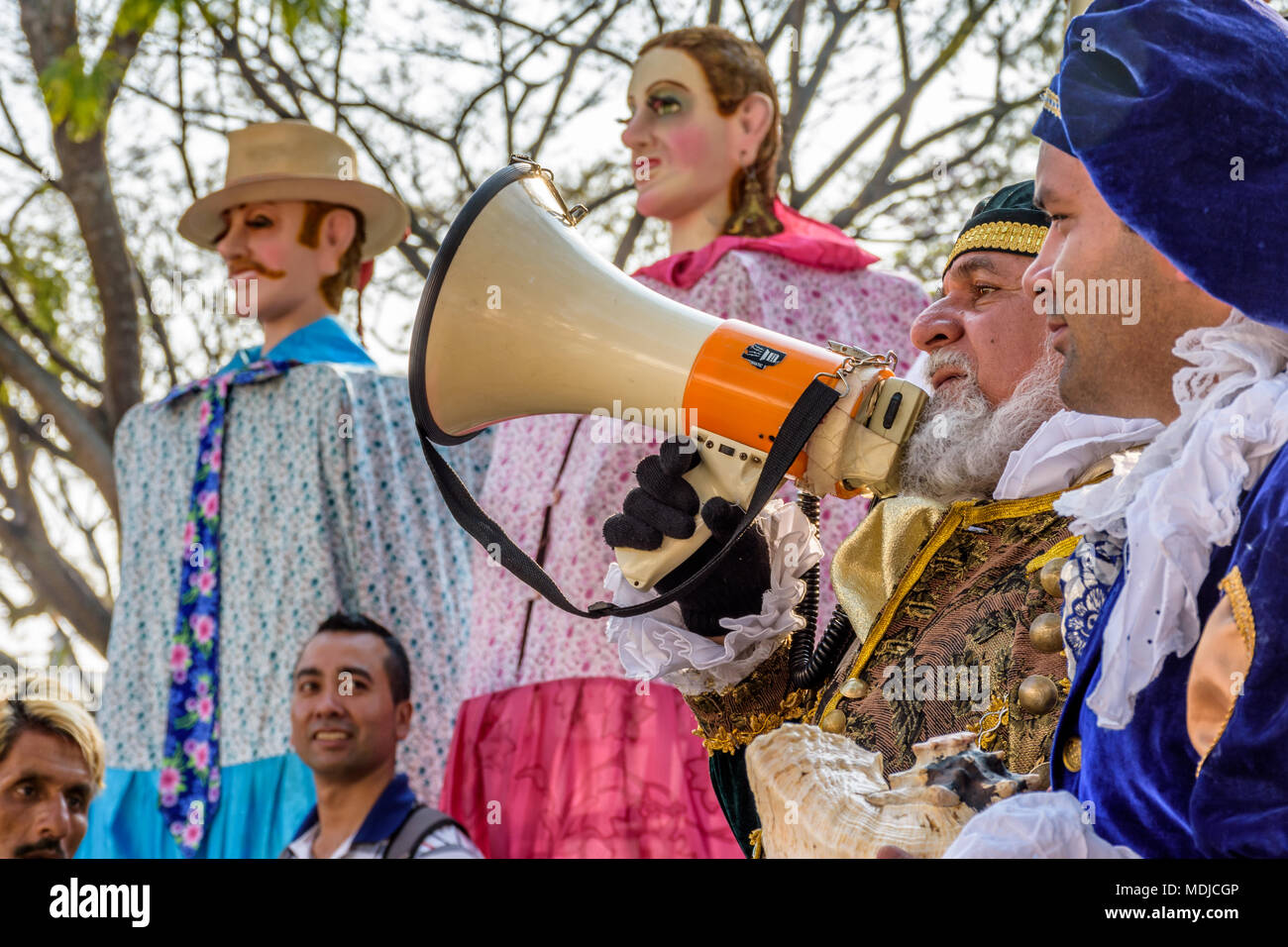 Antigua, Guatemala -  March 9, 2018: Man dressed up as colonial Spaniard announces dance of traditional giant folk dancing puppets called gigantes Stock Photo