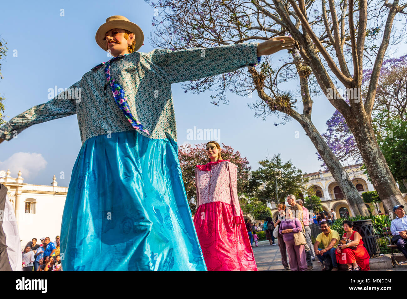 Antigua, Guatemala -  March 9, 2018: Dance of traditional giant folk dancing puppets called gigantes in central plaza in front of cathedral Stock Photo