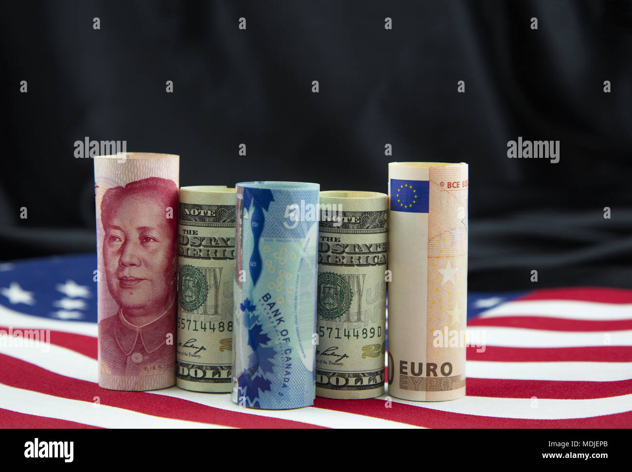 National currencies from China, United States, Canada, and European Union placed on American flag  reflect global nature of business Stock Photo