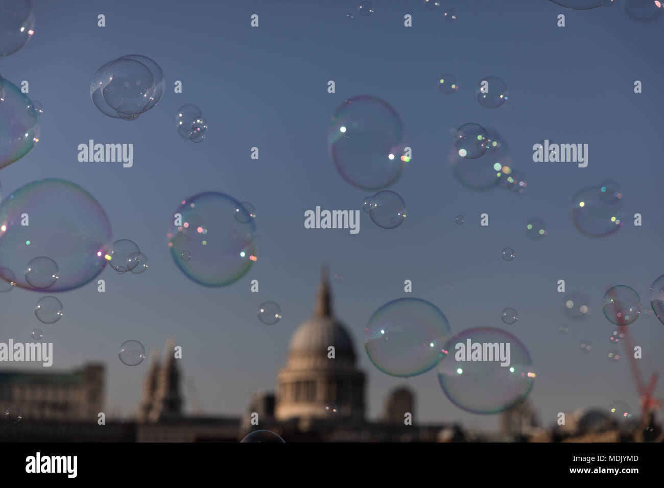 London, UK. 19th April, 2018. UK Weather: A busker makes bubbles for passers by on the southbank of the Thames during a beautiful evening in London, UK Credit: Carol Moir Stock Photo