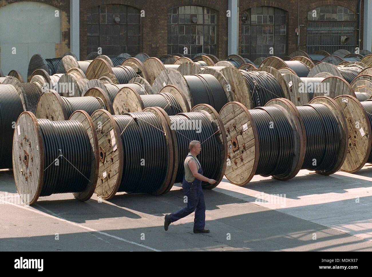 An employee walks on 21.8.1997 over the premises of the cable works in Berlin-Oberschoneweide. In front of the factory halls is a large number of cable reels. The operation of the British company will merge with a manufacturer from Holland and thereby abandon the site of the former cable factory Oberspree (KWO). As a result of this merger, about half of the 1,200 jobs will be lost. | usage worldwide Stock Photo