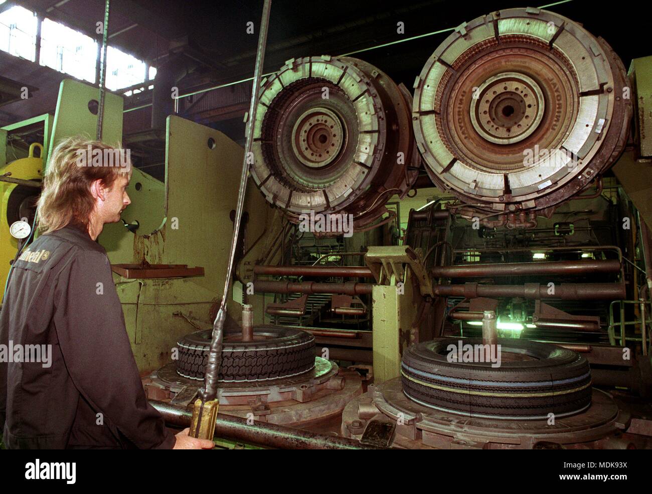 A worker at the open air press for the vulcanization of truck tires. Taken on June 8, 1994. | usage worldwide Stock Photo