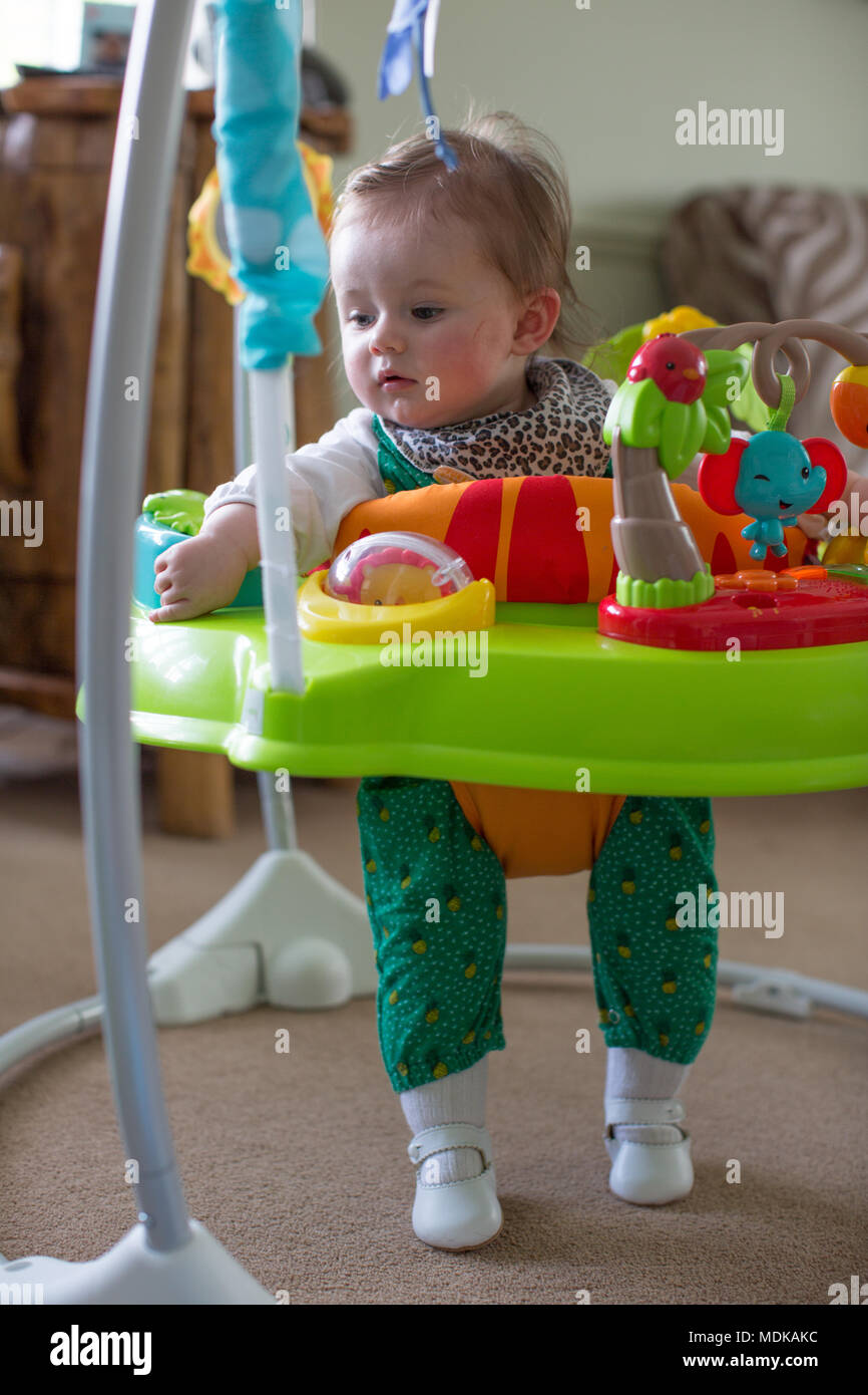 Baby in jumperoo watching television Stock Photo
