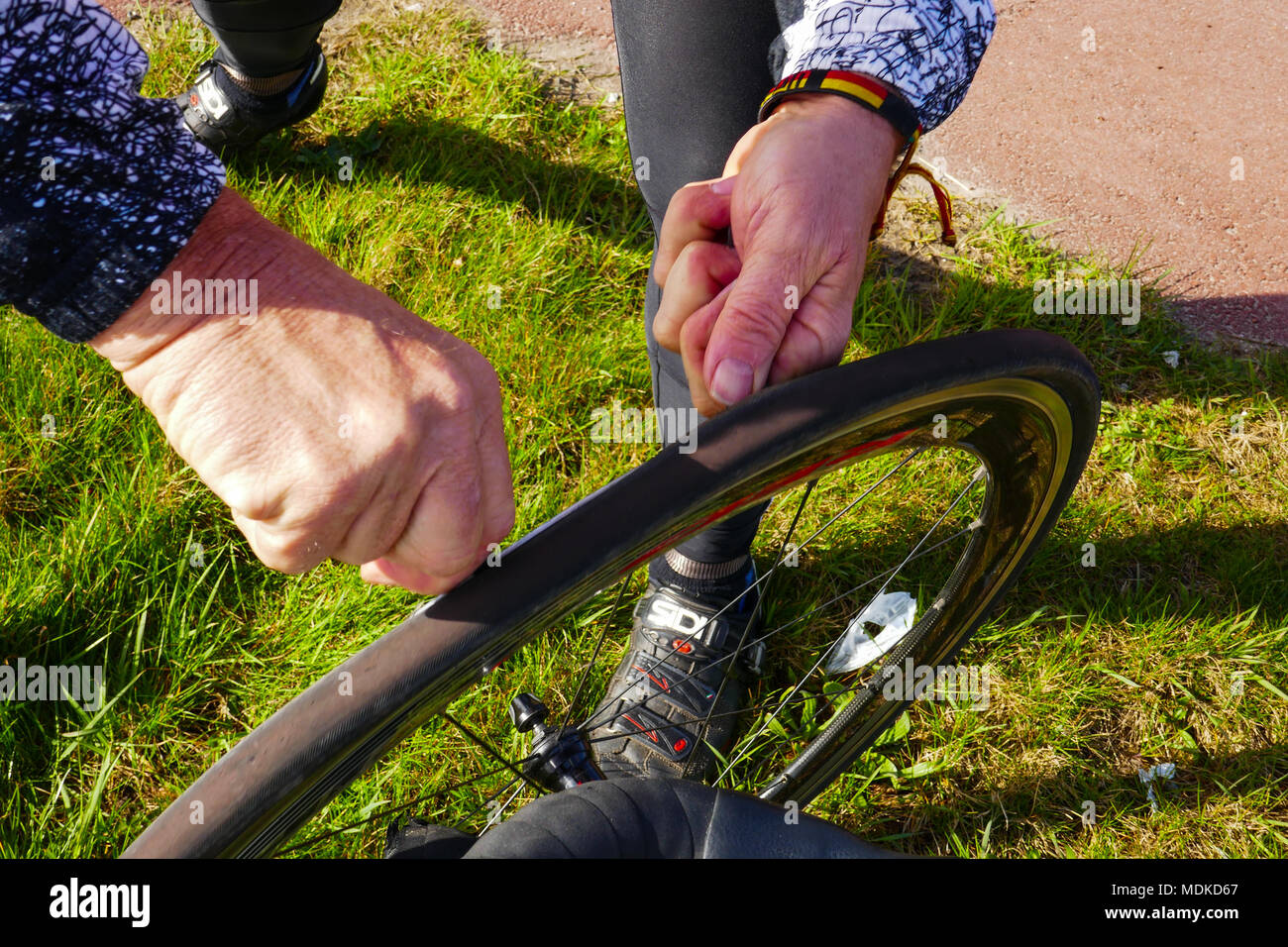 repairing a flat tyre of a bicycle on the road in Holland Stock Photo