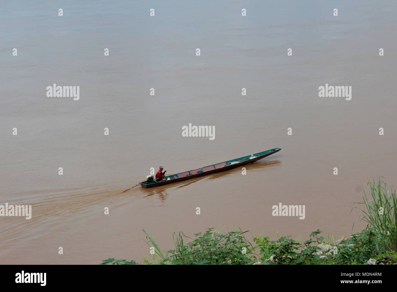 A boater on the Mekong River near Wat Sibounheuang temple, Vientiane, Laos, 2016. Stock Photo