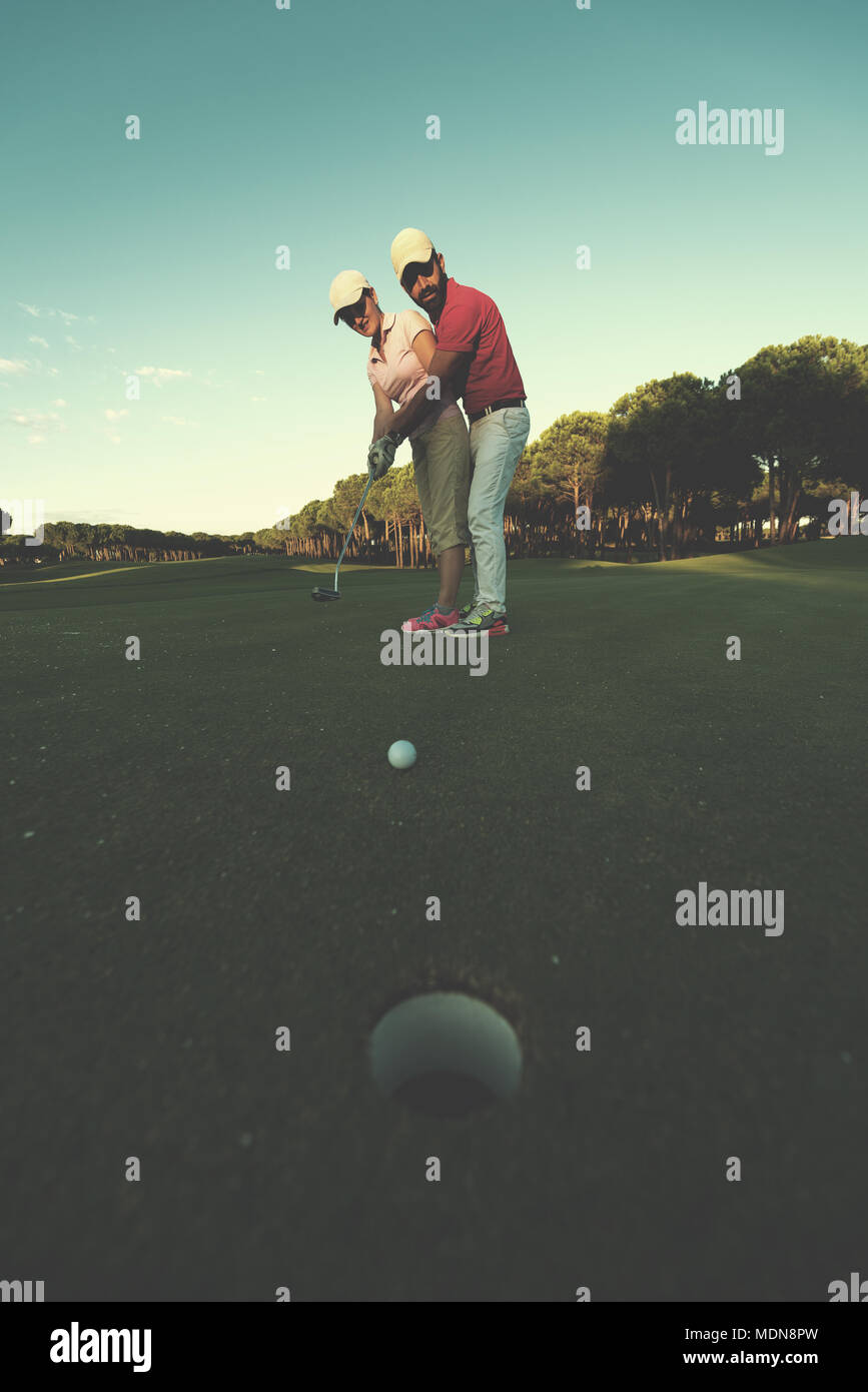 male golf instructor teaching female golf player, personal trainer