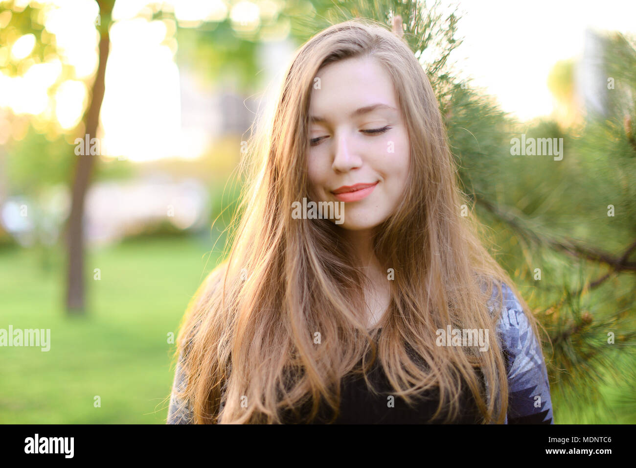 Dreaming woman near cedar wood with green grass background Stock Photo Alamy