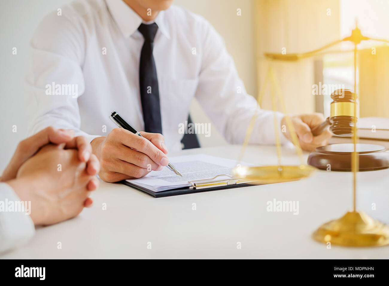 Justice and Law concept. Legal counsel presents to the client a signed contract with gavel and legal law or legal having team meeting at law firm in b Stock Photo