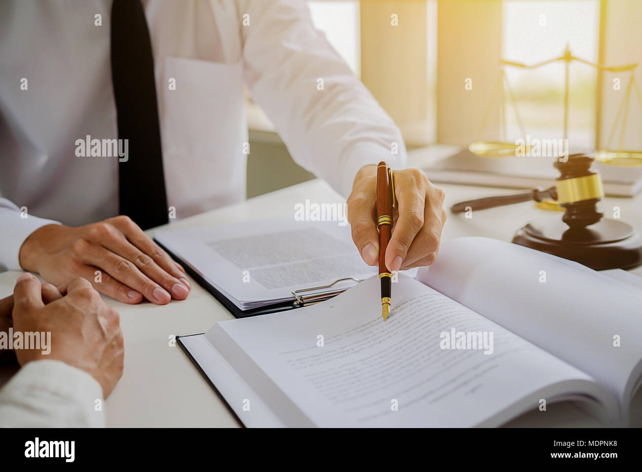 Justice and Law concept. Legal counsel presents to the client a signed contract with gavel and legal law or legal having team meeting at law firm in b Stock Photo
