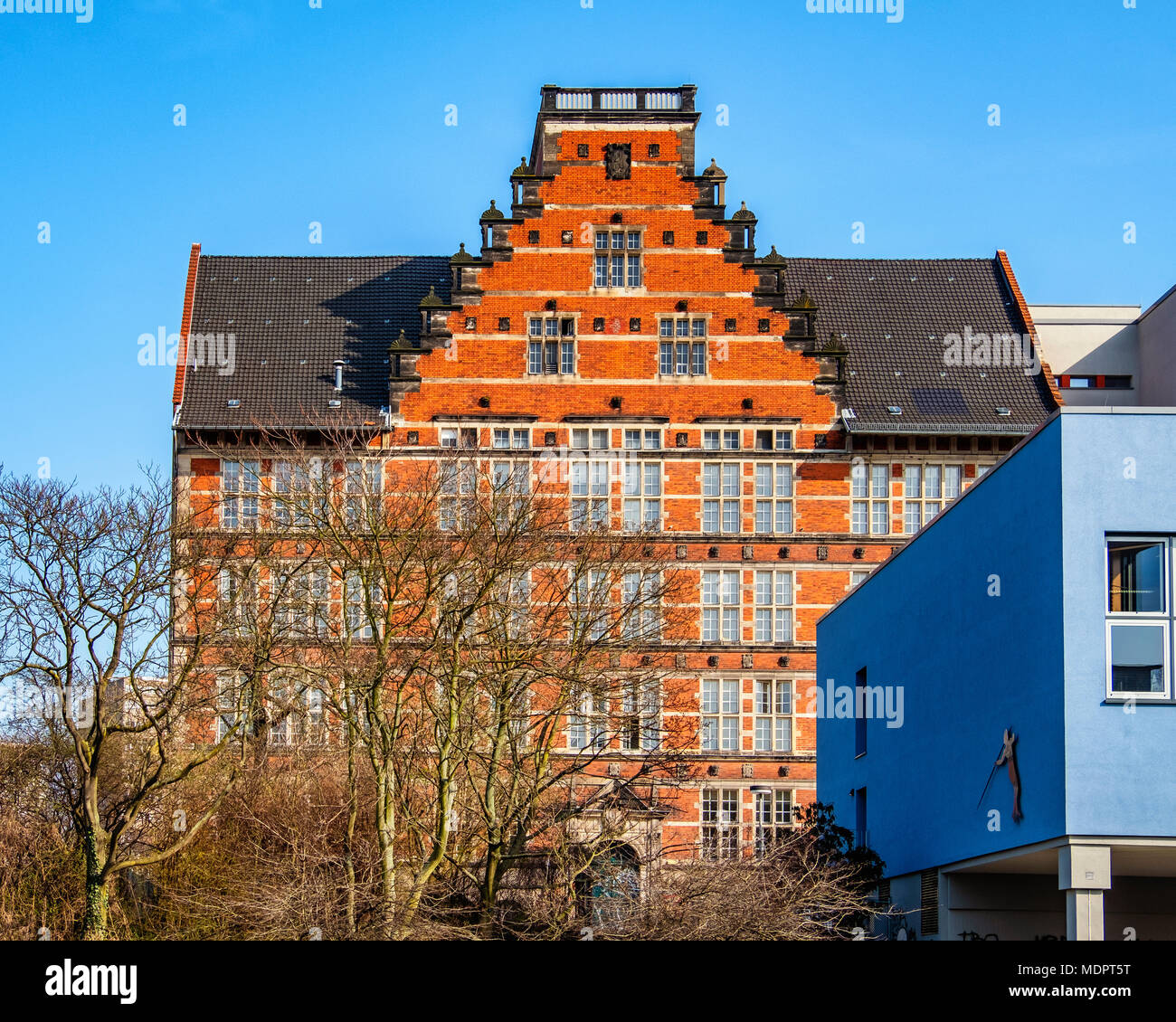 Berlin Moabit Gymnasium Tiergarten. Senior school in historic old listed brick building and modern blue cuboid auditorim Stock Photo