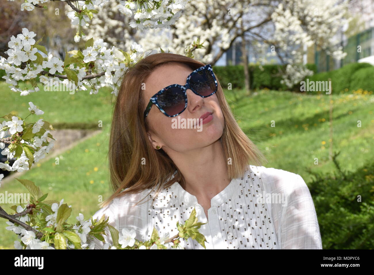 Young woman posing with cherry tree Stock Photo
