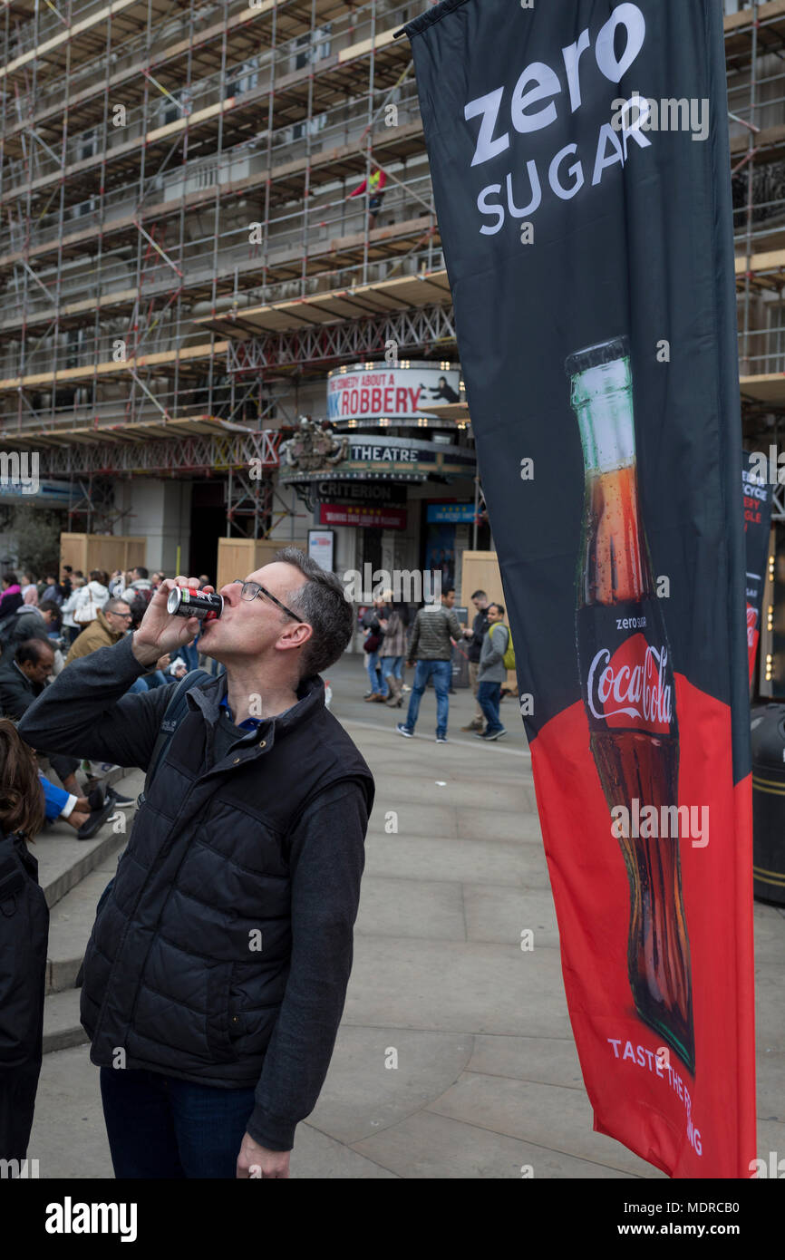 A passer-by tastes a sample of the new Zero Sugar (Sugar Free) Coca-Cola drinks, given out in Piccadilly Circus, on 16th April 2018, in London, England. Stock Photo