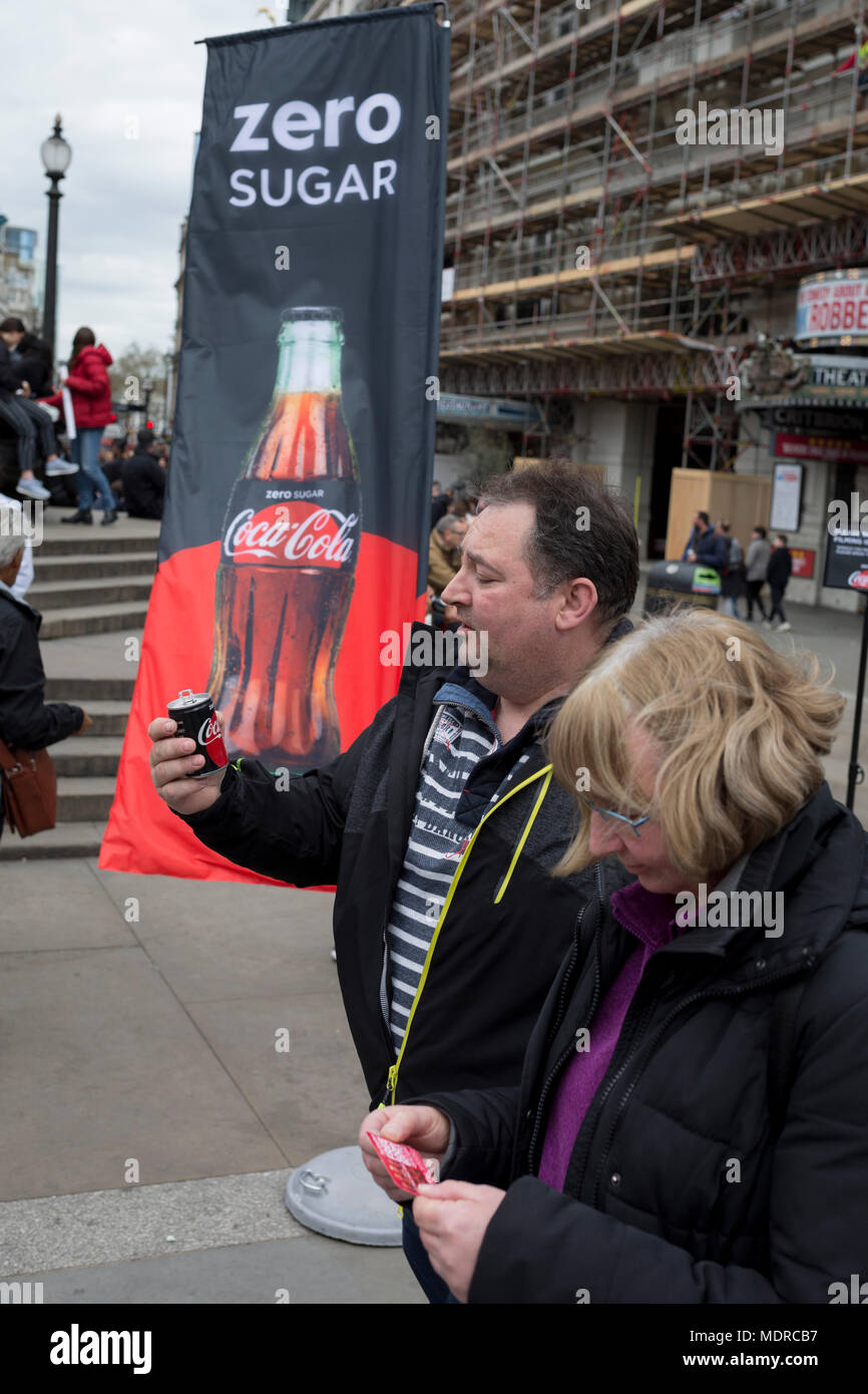 A passer-by tastes a sample of the new Zero Sugar (Sugar Free) Coca-Cola drinks, given out in Piccadilly Circus, on 16th April 2018, in London, England. Stock Photo