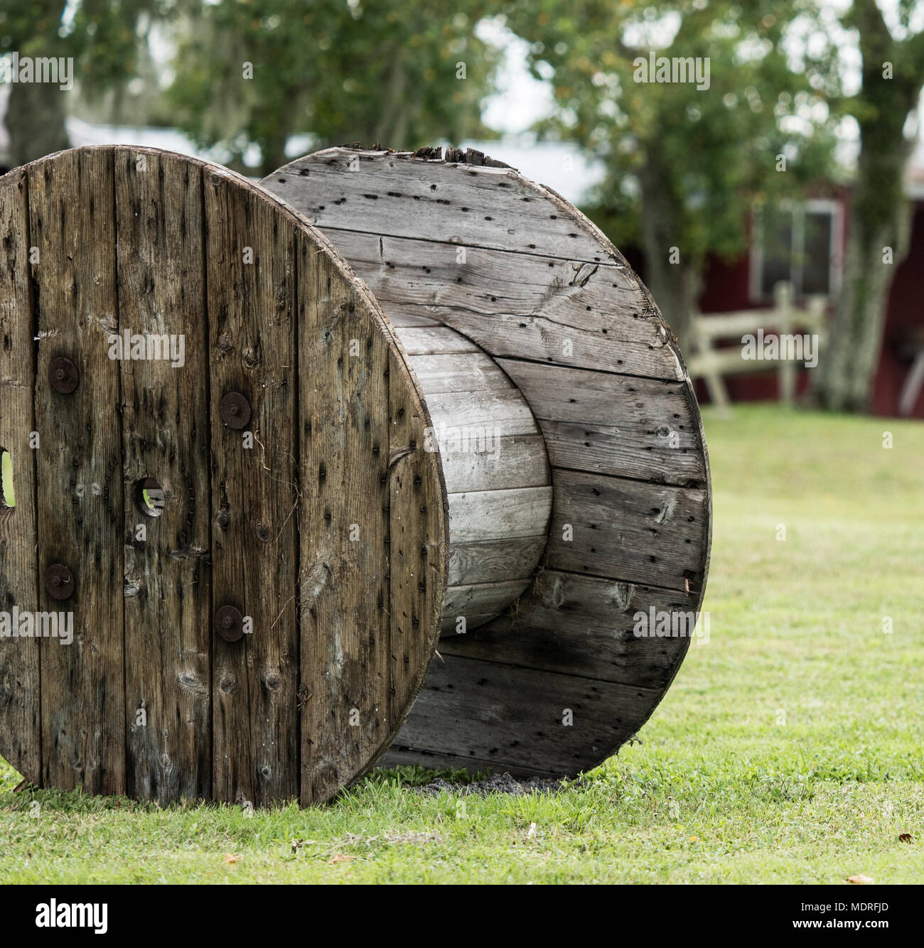 A large old empty wooden cable spool on grass Stock Photo - Alamy