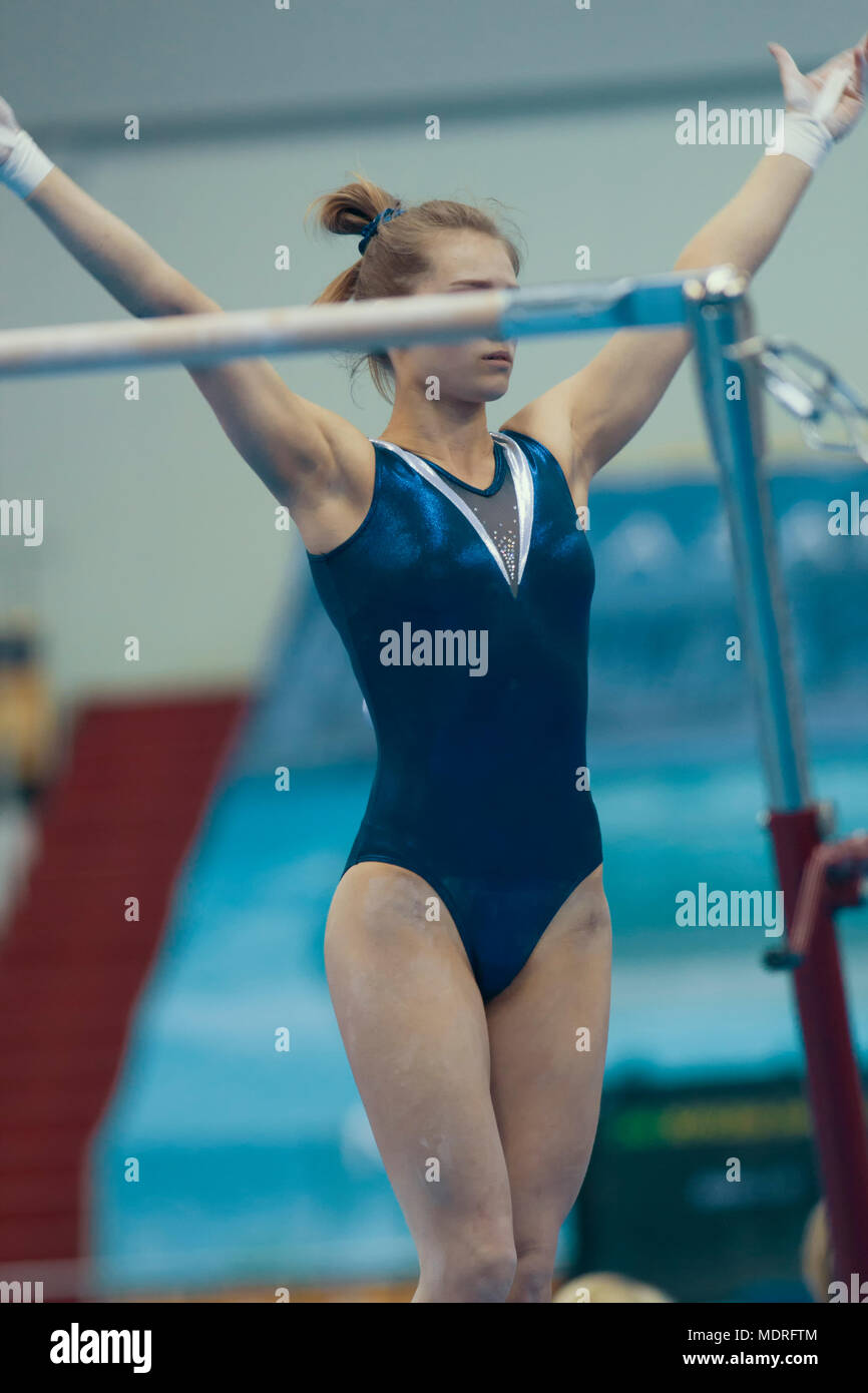 Athletic girl gymnast get ready in uneven bars at the championship