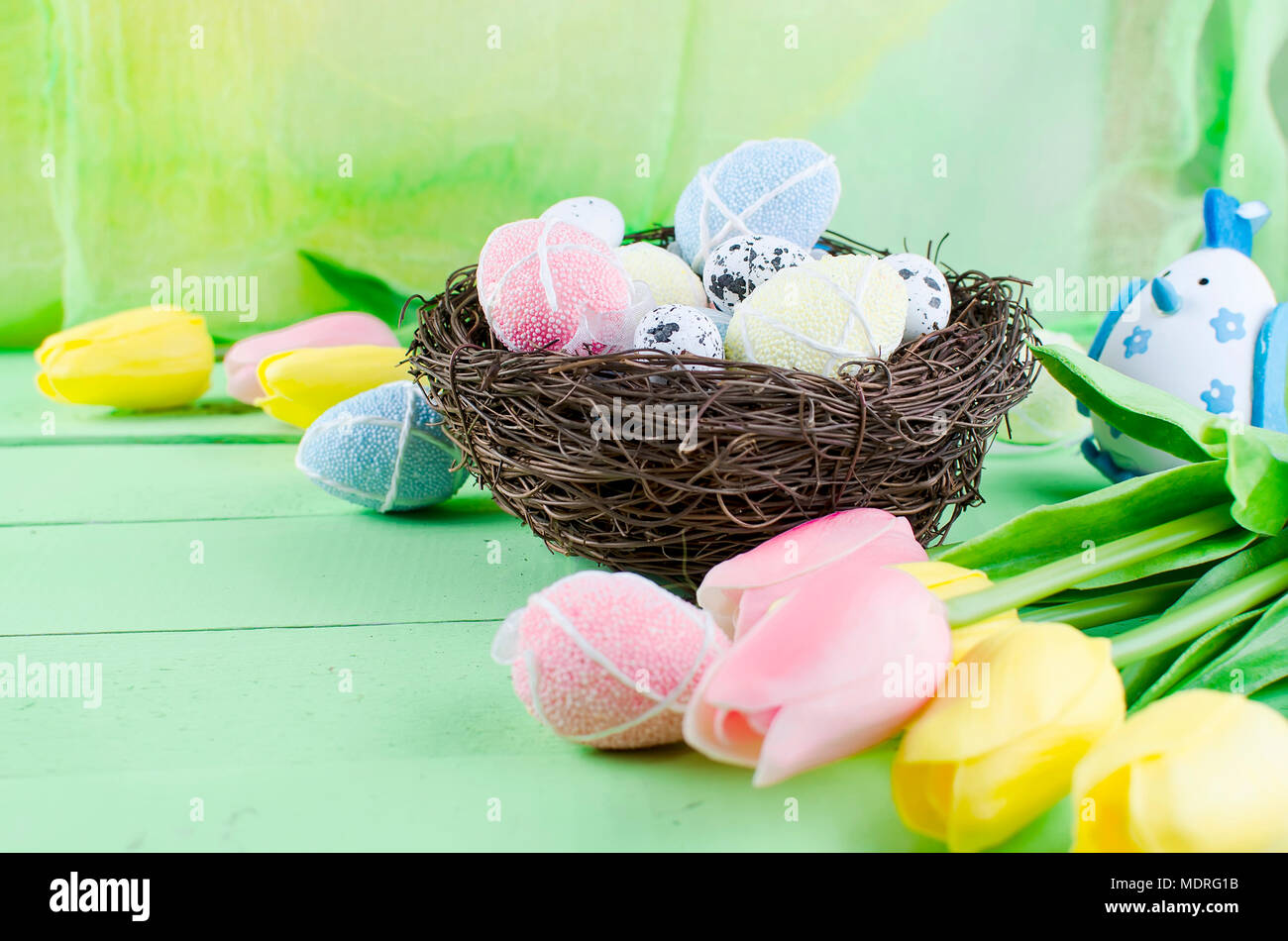 Decorative eggs toys in the nest and tulips for Easter on thelight ...