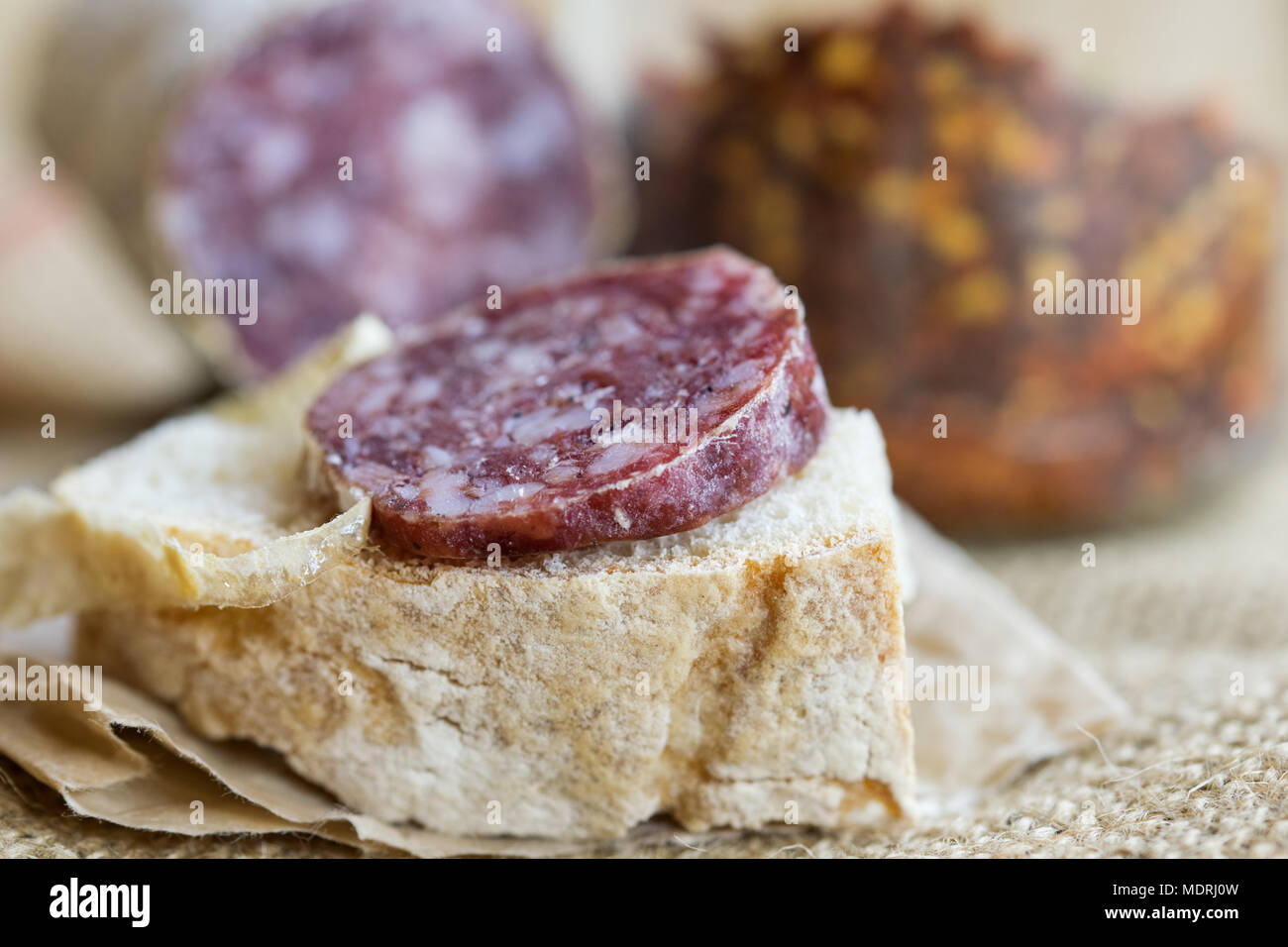 slice of hot salami with crushed hot pepper on a piece of bread Stock Photo