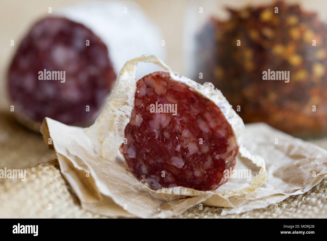 slice of hot salami with crushed hot pepper on a background Stock Photo