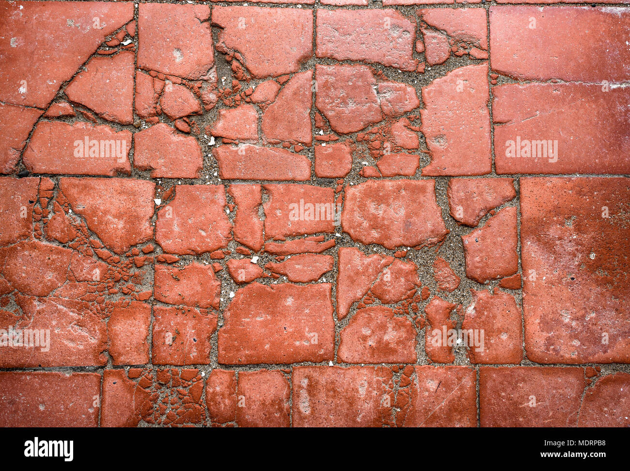 Old terracotta cracked and broken tiled floor. Stock Photo