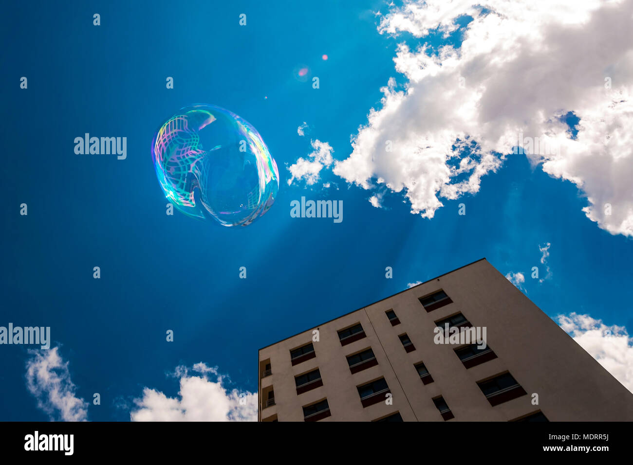 Soap bubble in blue sunny sky, over city blocks. Freedom concept. Stock Photo