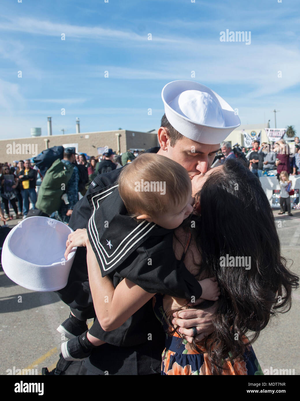 171205-N-BN355-0257  SAN DIEGO (Dec. 05, 2017) Aviation Electrician's Mate 1st Class Nathaniel Klein embraces his wife and son after disembarking from USS Nimitz. The Nimitz Carrier Strike Group is on a regularly scheduled deployment to the Western Pacific. The U.S. Navy has patrolled the Indo-Asia-Pacific region routinely for more than 70 years, prompting peace security. (U.S. Navy photo by Mass Communication Specialist Seaman Apprentice Jailene Casso/Released) Stock Photo